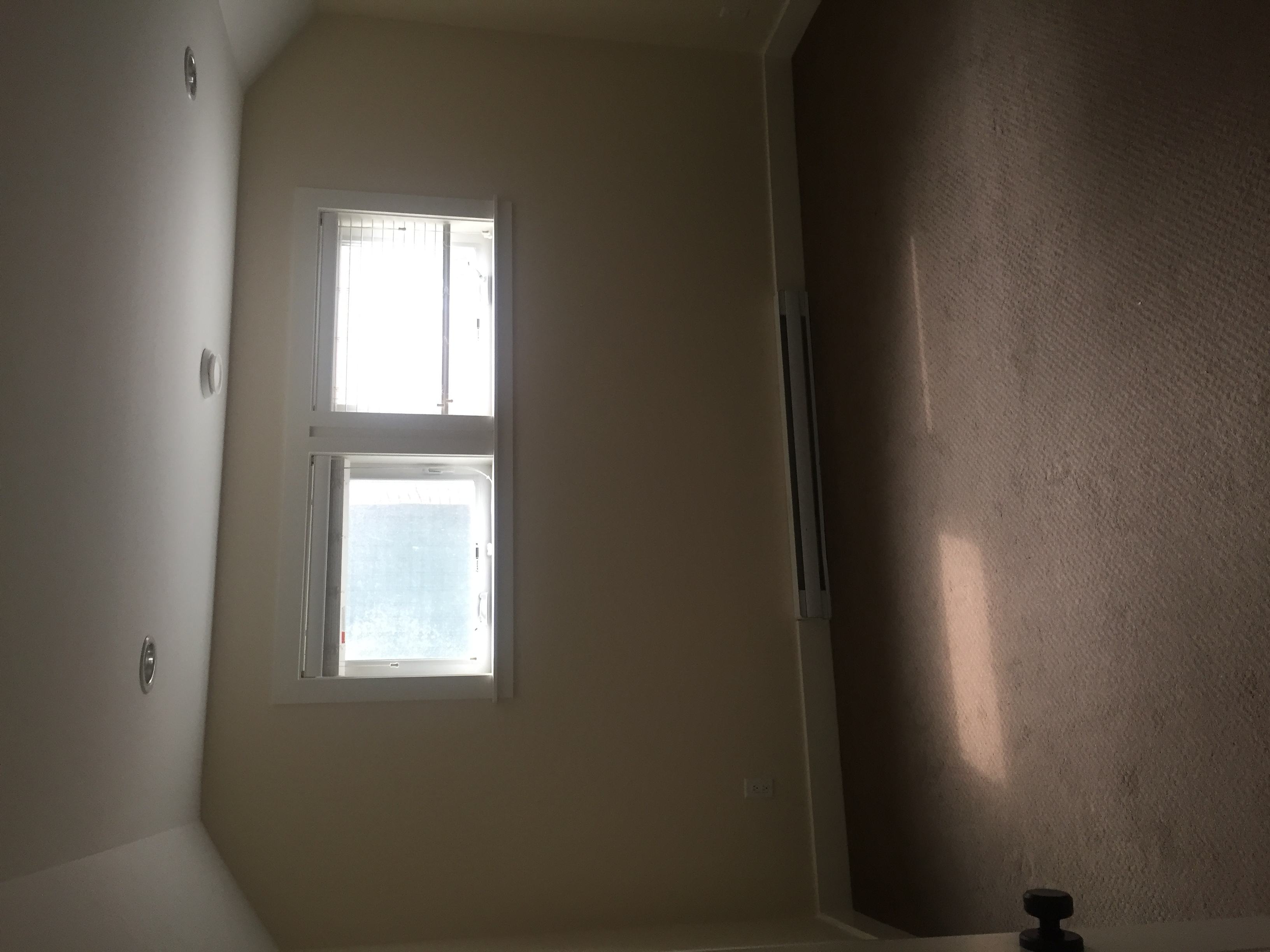 A window in a room with a white wall.